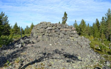 Kuvassa taustalla kesäinen havumetsä. Keskellä kuvaa on Piispankivi, joka on suuri luonnonkivistä ladottu kuutiomainen rakennelma Tornion Iso-Huituri -saaren pohjoisosassa sen korkeimmalla kohdalla (5–7,5 m mpy.). Sen seinämät on ladottu kookkaista kivistä nelikulmion muotoon. Suurin sivun pituus on n. 6 m, ja korkeutta pyykillä on yli 2,5 m.